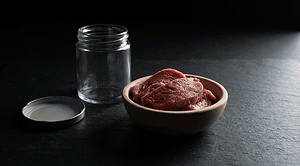 Cultivated meat grown from animal cells, set against the question of whether it belongs on a vegan's plate.